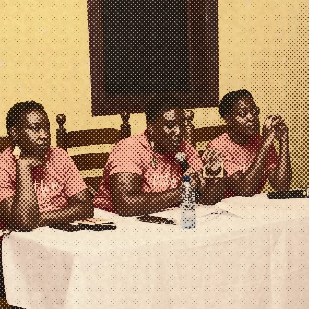 Three women in red festival T-shirts speaking at a panel table, 2023 festival